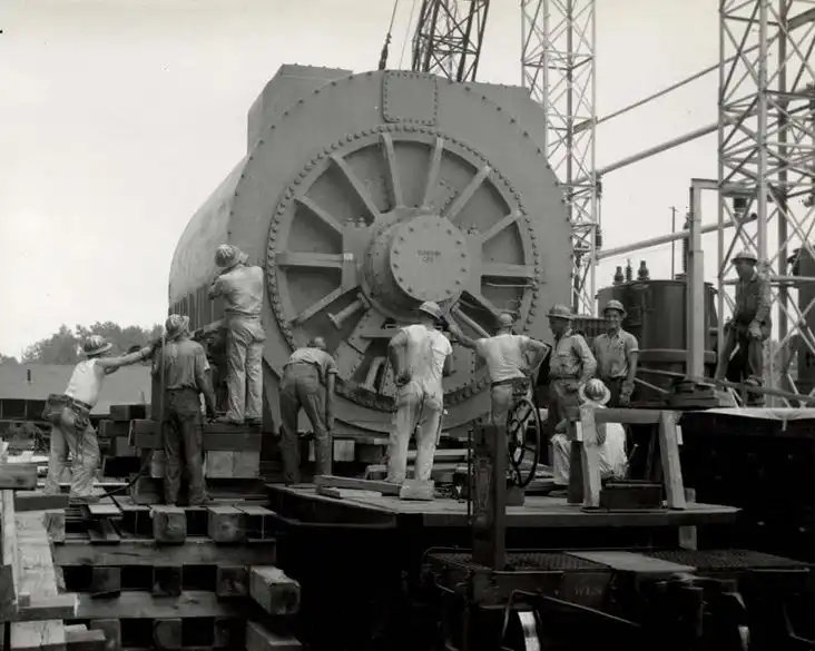 View of generator looking East while preparations are being made to skid generator off railroad car - Aug. 2, 1956